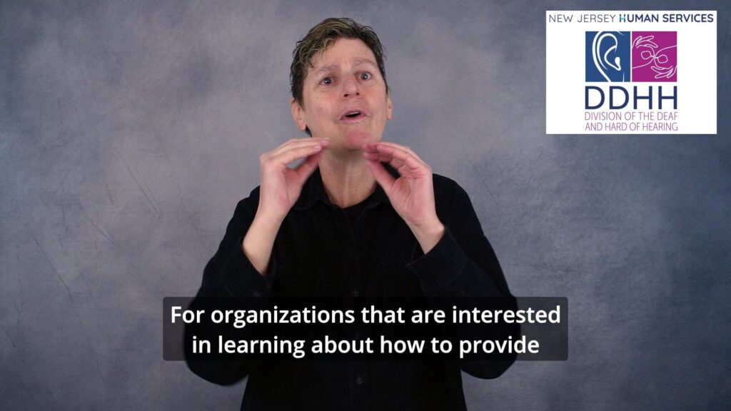 A still from one of the delivered videos: a Certified Deaf Interpreter signs to camera against a plain grey backdrop, with the New Jersey Human Services DDHH logo in the top corner and an open caption reading 'For organizations that are interested in learning about how to provide' across the lower third.