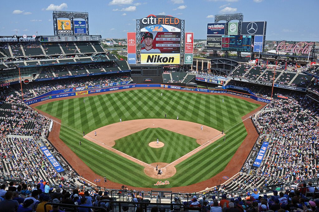 Citi Field seen from the upper deck during a Mets game, the mown stripes of the outfield below a full lower bowl.