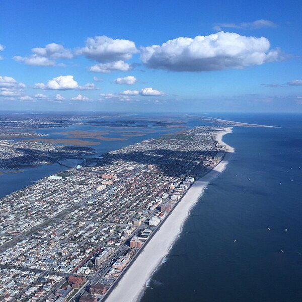 The boardwalk at Long Beach running above the sand, the Atlantic breaking beyond it.
