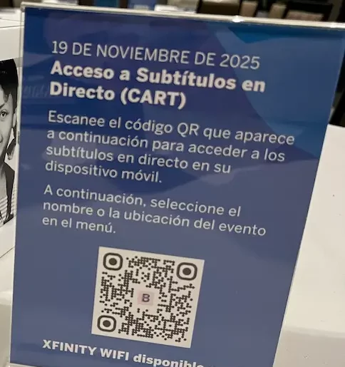 Step 1 in Spanish: the same tabletop captioning sign headed '19 de noviembre de 2025, Acceso a Subtitulos en Directo (CART)', with a QR code and instructions to select the event name or location from the menu.