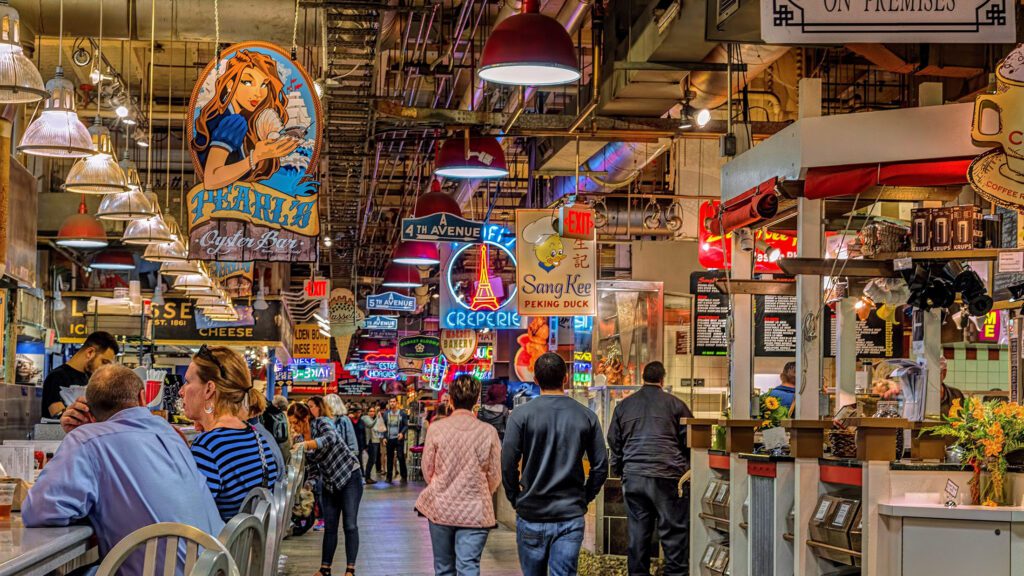 The crowded aisles of Reading Terminal Market beneath its hanging vendor signs.