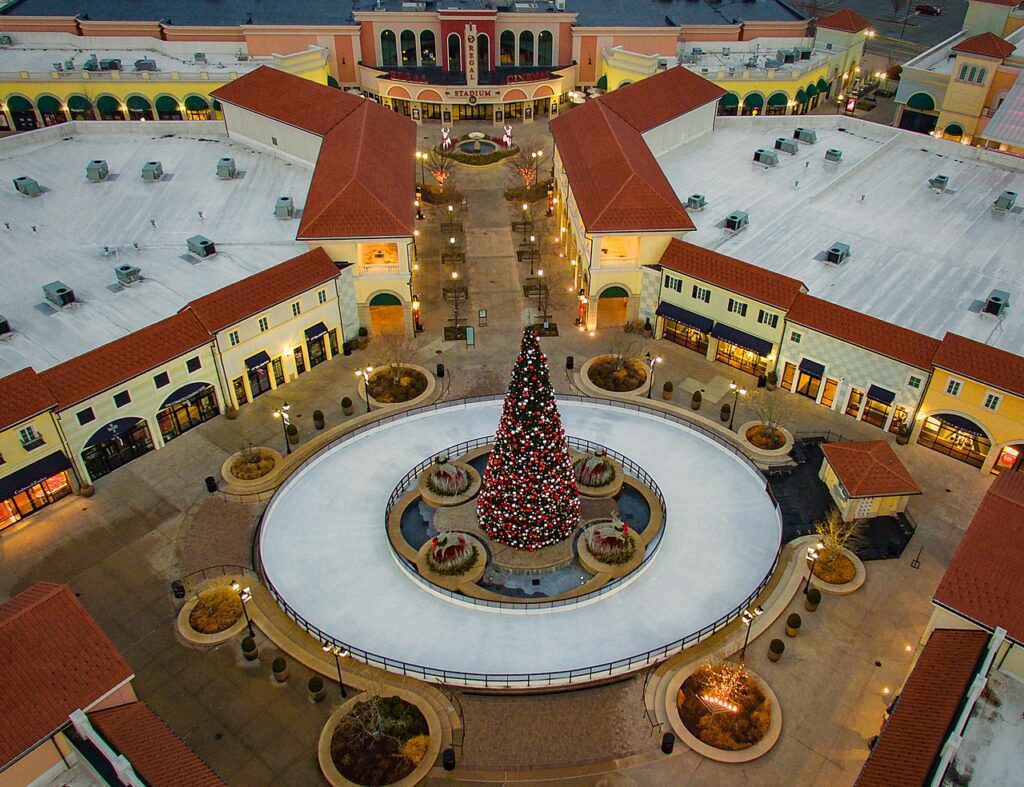The open-air walkways of Tanger Outlets Deer Park lined with shopfronts.
